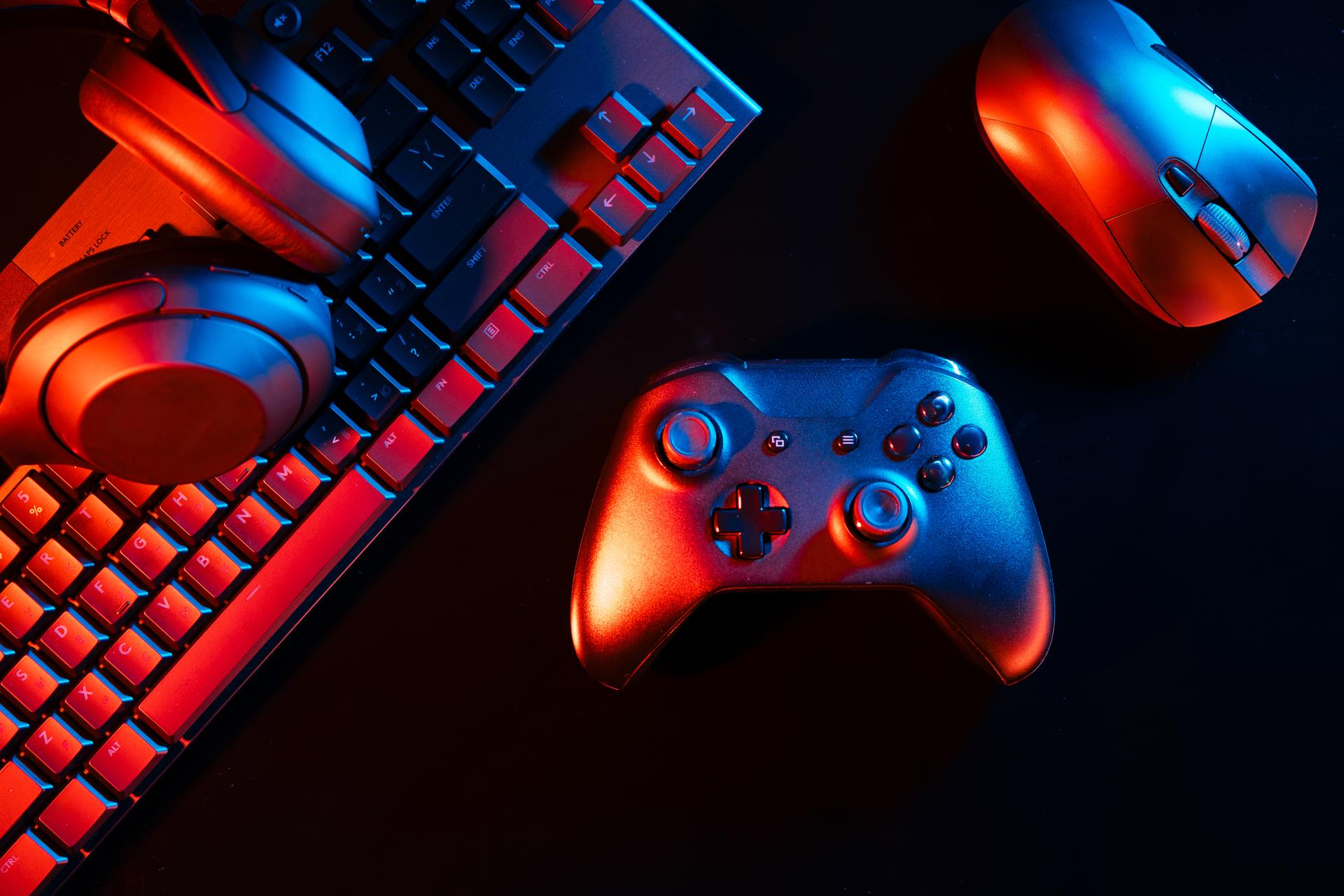 Computer keyboard, mouse and joystick on black background